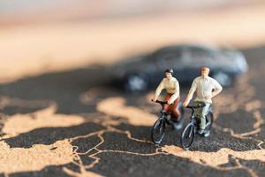 Viajeros en miniatura con bicicletas sobre un fondo de mapa del mundo foto