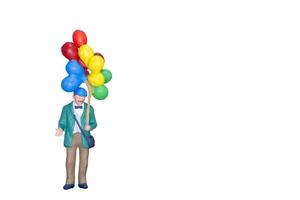 Miniature person holding balloons isolated on a white background photo