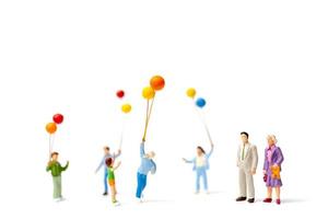 Miniature people holding balloons isolated on a white background photo