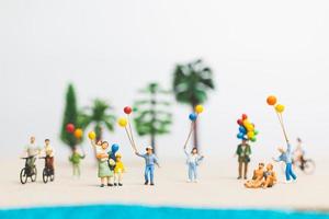 Gente en miniatura disfrutando de las vacaciones de verano en la playa. foto