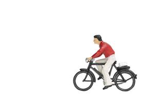 Viajero en miniatura con una bicicleta aislado sobre un fondo blanco. foto