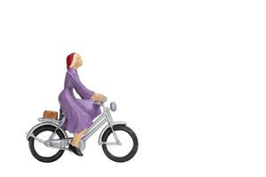Miniature traveler with a bicycle isolated on a white background photo