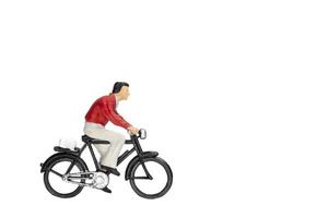 Miniature traveler with a bicycle isolated on a white background photo