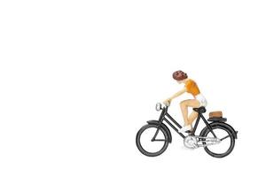 Miniature traveler with a bicycle isolated on a white background photo