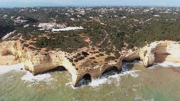 cámara lenta, imágenes de drones aéreos que vuelan hacia una formación rocosa única que se encuentra a lo largo de la costa cerca del pueblo costero de benagil, portugal. video