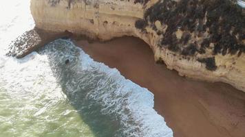 Golden beach and rock outcroppings in Carvoeiro, Algarve, Portugal - Descent Aerial shot