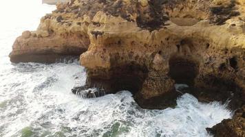 luchtfoto 4k drone-opnames die de rotsachtige kustlijnkliffen in de buurt van de stad Carvoeiro, Portugal onthullen.