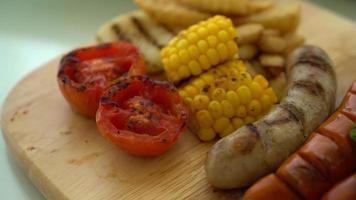 sartén sobre salchichas a la parrilla y verduras mixtas video