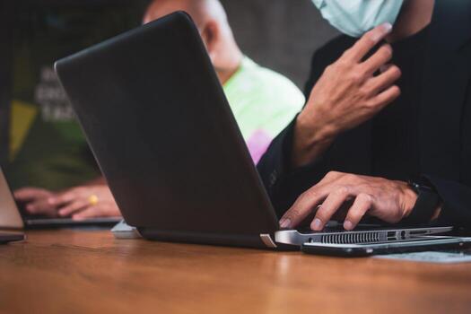 dos personas hablando en la oficina y trabajando con ordenadores portátiles foto