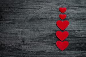 Red heart column on dark old wooden background photo