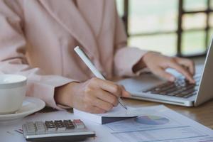 Young businesswoman working on laptop at her workstation photo