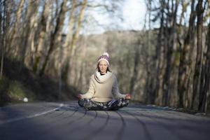 A young athletic woman performs yoga and meditation exercises outdoors photo