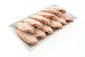 Raw chicken wings on white plate photo