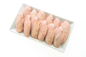 Raw chicken wings on white plate photo