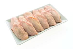 Raw chicken wings on white plate photo