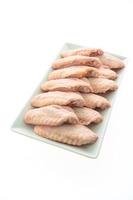 Raw chicken wings on white plate photo