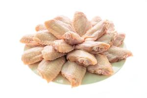 Raw chicken wings on white plate photo