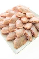 Raw chicken wings on white plate photo