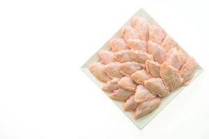 Raw chicken wings on white plate photo