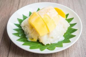 Arroz pegajoso con mango en la placa blanca. foto