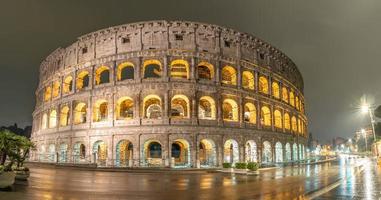 Vista nocturna lluviosa del Coliseo en Roma, Italia