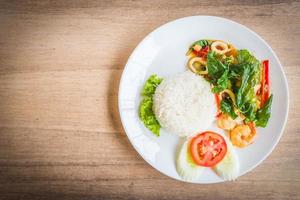 Spicy fried basil leaf with seafood and rice photo