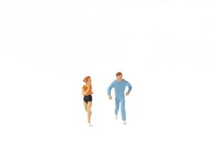 Miniature people running isolated on a white background photo