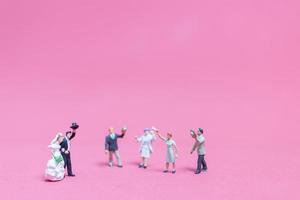 Miniature wedding, a bride and groom on a pink background photo