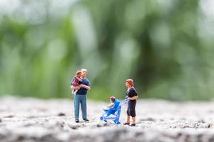 Miniature parents with children walking outdoors, happy family concept photo