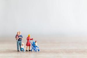 Miniature parents with children walking outdoors, happy family concept photo