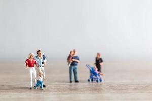 Miniature parents with children walking outdoors, happy family concept photo