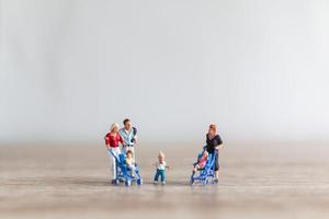 Miniature parents with children walking outdoors, happy family concept photo