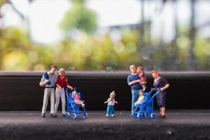 Miniature parents with children walking outdoors, happy family concept photo