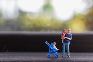 Miniature parents with children walking outdoors, happy family concept photo