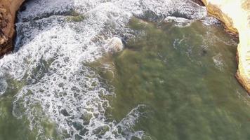 Waves washing on cliff.  Aerial reveal of Carvoeiro coastline. Tilt up shot video