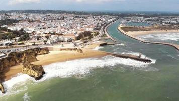 Panoramic view of the beach, marina and cityscape, Lagos, Algarve, Portugal. Aerial froward video