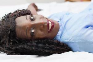 Smiling young woman lying down and looking at the camera photo