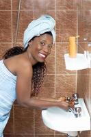 Happy young woman washes her face photo