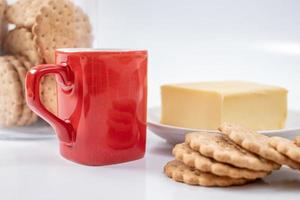 Red coffee mug with cookies on white background photo