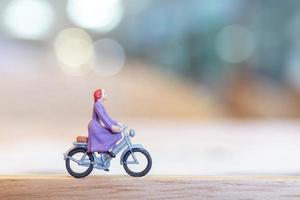 Persona en miniatura en bicicleta sobre un puente de madera, concepto de salud foto