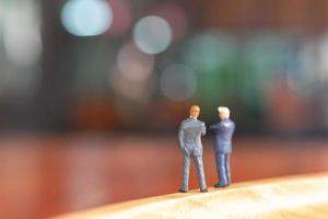 Miniature businessmen standing and thinking with a colorful background photo
