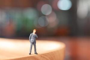 Miniature businessman standing and thinking with a colorful background photo