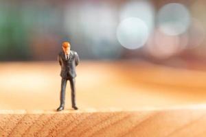 Miniature businessman standing and thinking with a colorful background photo