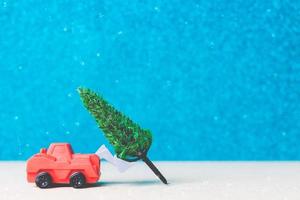 árbol de navidad en un coche en miniatura, concepto de celebración de la temporada navideña foto