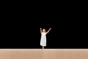 Miniature woman suffering from somnambulism at home on a black background photo