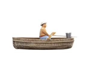 Miniature person sitting in a boat on a white background photo
