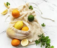 Juicy ripe citrus fruits in an eco-friendly shopping bags photo