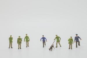 Miniature police officers with police dogs sniffing evidence on a white background photo