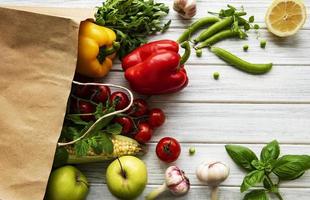 Paper bag with fruits and vegetables, eco friendly, flat lay photo