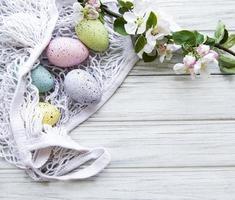 bolsa de hilo con huevos de pascua y flor de primavera foto